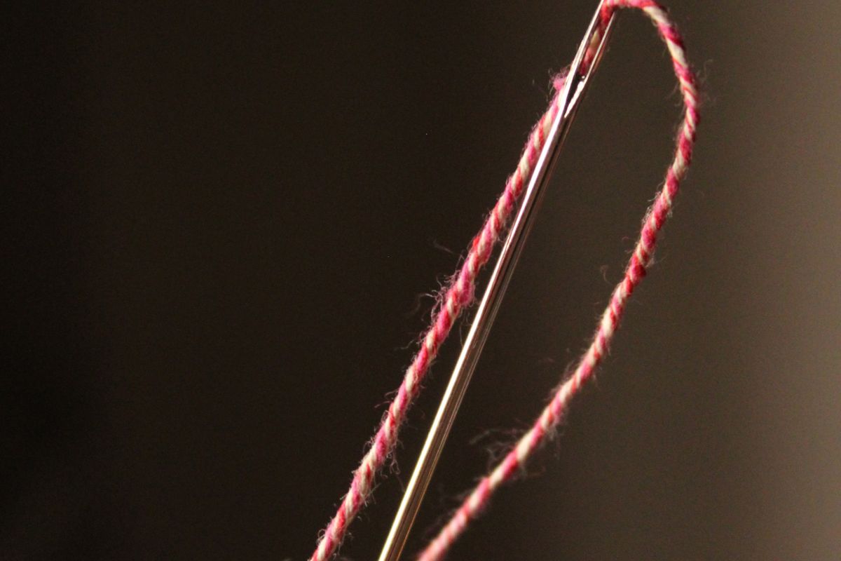 Close-up of a needle threaded with yarn