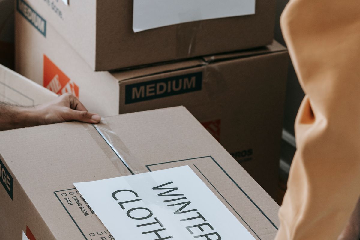 Sealing a box of winter clothes for storage