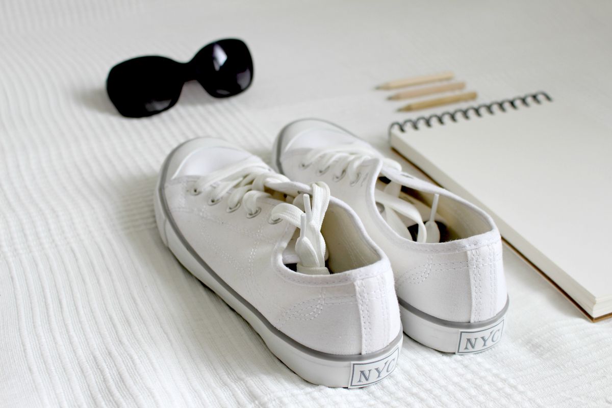 A pair of white canvas sneakers laid flat